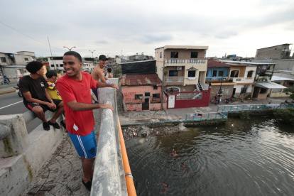 Ocio. Un grupo de jóvenes se baña en el Salado bajo el puente de la calle 17, en el suroeste guayaquileño.