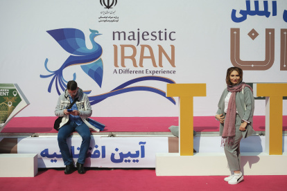 Una mujer. Posa frente al eslogan de la campaña turística oficial del país.