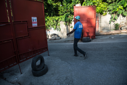 Un hombre cruza una barrera a la entrada de un barrio, este domingo en Puerto Príncipe (Haití).