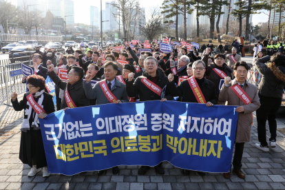 Los médicos portan una pancarta mientras marchan hacia la oficina presidencial en el distrito de Yongsan, Seúl, Corea del Sur, el 25 de febrero de 2024.
