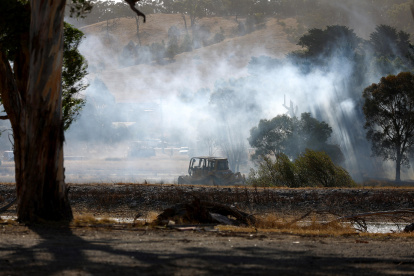 Un vehículo se encuentra en un campo mientras arde un incendio en las afueras de Beaufort, Victoria, Australia, el 28 de febrero de 2024.