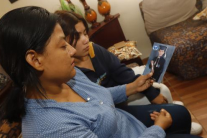 La madre de Carlos sostiene una foto de su hijo, recordándolo durante su época colegial.