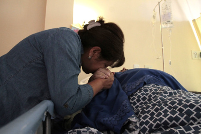 Elsa Carranco consiente a su esposo Gustavo Landázuri, quien enfrenta una enfermedad neurológica degenerativa.