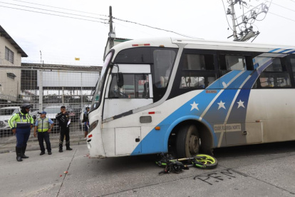 La moto quedó debajo del transporte urbano, mientras que los cascos de los ocupantes quedaron tirados en la avenida.