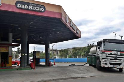 Un carro tanque de combustibles abastece una gasolinera