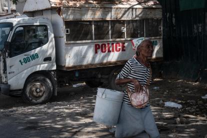 Caso. Una mujer camina frente la prisión nacional, en Puerto Príncipe, donde se dio una de las fugas masivas.
