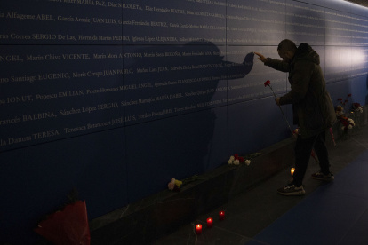 Una persona deposita un clavel en memoria de las víctimas del 11-M.