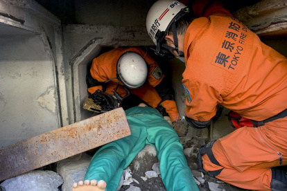 Efectivos del cuerpo de bomberos de Tokio llevan a cabo una demostración del rescate de una víctima atrapada bajo escombros.