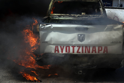 Fotografía de un vehículo en llamas durante una protesta frente a las instalaciones de la Fiscalía General del Estado (FGE) de Guerrero este martes, en Chilpancingo (México).
