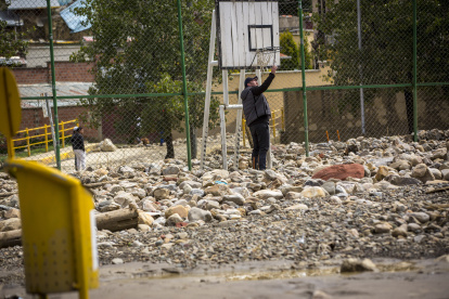 Una persona camina en medio de las piedras y escombros que quedaron en un parque tras el desborde de un río, el 9 de marzo, en La Paz.