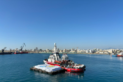 na fotografía proporcionada por World Central Kitchen (WCK) muestra el barco de rescate de la ONG Open Arms (C) siendo remolcado en mar abierto arrastrando una barcaza (frente) cargada con ayuda alimentaria proporcionada por WCK, mientras sale del puerto con destino a la Franja de Gaza.