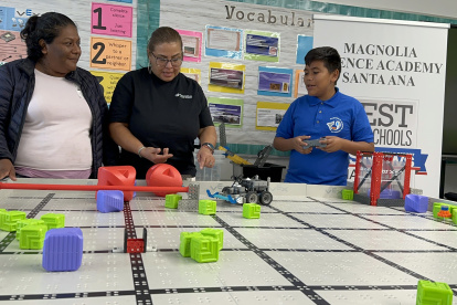 Aracely Vargas (i), su hijo, el estudiante de sexto grado Joel Rodrigue durante su participación en la primera Competencia Anual de Robótica VEX