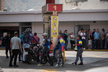 Varias personas hacen fila para abastecerse de combustible