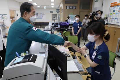 El primer ministro surcoreano, Han Duck-soo (i), le da la mano a una enfermera durante una visita al Centro Médico Masan en Masan, a unos 298 km al sureste de Seúl, Corea del Sur, el 15 de marzo de 2024, en medio de una huelga en todo el país.