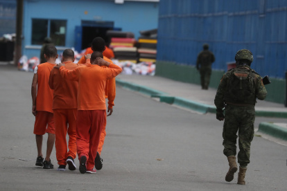 Un militar custodia a reclusos mientras se trasladan dentro de la cárcel de Cotopaxi.