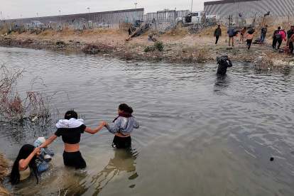 Migrantes se preparan para cruzar el Río Bravo, en la frontera que divide a México de los Estados Unidos, en un punto de Texas