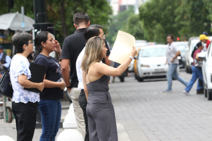 Los guayaquileños han intentado durante estos días cubrirse del sol o refrescarse con lo que hallen a la mano: carpetas, hojas, abanicos...