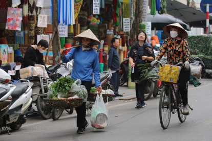 Un vendedor ambulante que camina por una calle de Hanoi, en Vietnam, 13 de marzo de 2024