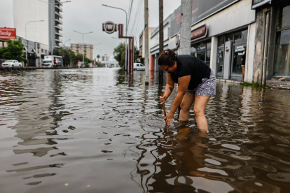Una mujer en medio de una calle inundada por la lluvia el 20 de marzo de 2024, en Buenos Aires