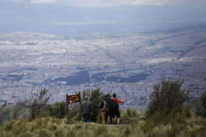 Un grupo de turistas visitan el teleférico en Quito.