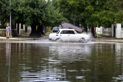 Un auto cruza por una calle anegada por las fuertes lluvias este sábado en La Habana (Cuba).