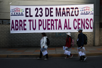 Voluntarios se desplazan por una calle durante el censo de población y vivienda este sábado 23 de marzo, en La Paz.
