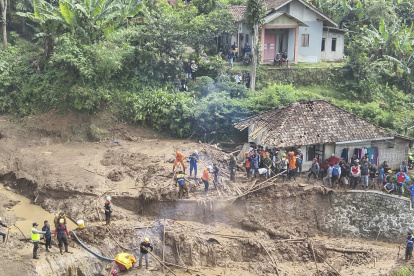 Los equipos de rescate tratan de localizar a los desaparecidos entre las montañas de escombros dejadas por la avalancha que golpeó decenas de casas.