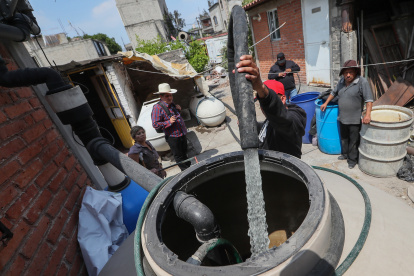 Un hombre llena unos tanques con agua, el 19 de marzo del 2024, en el pueblo de Santa María Aztahuacan, en la Ciudad de México (México).