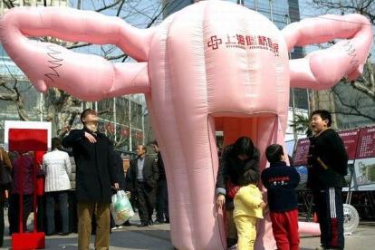 Visitantes observan una réplica hinchable de un útero humano en un áera comercial de Shanghai,