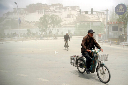 Un hombre sobre una bicicleta después de una tormenta de arena en China.