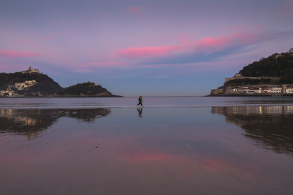 Archivo. Dos personas corren al amanecer por la orilla de la playa de La Concha de San Sebastián
