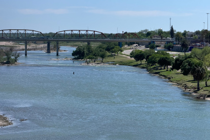 Un migrante (c) desiste de ingresar a Estados Unidos y se regresa a la población de Piedras Negras, (Cohauila, México), atravesando el Rio Bravo este sábado, en Eagle Pass, Texas (Estados Unidos).
