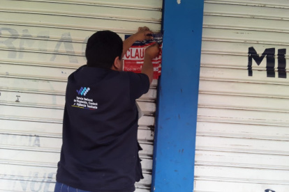Medida.- Un delegado de Arcsa pone el sello de clausura a una farmacia.