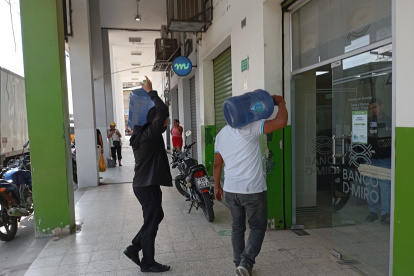 Recurso. Ciudadanos compran bidones de agua ante la escasez.