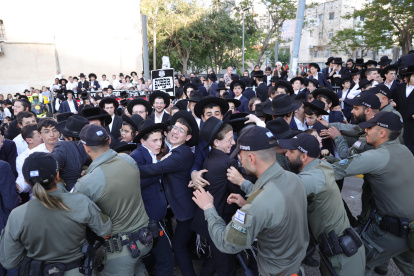 La policía retiene a judíos ultraortodoxos durante una protesta contra el reclutamiento militar frente a la oficina de reclutamiento militar en Jerusalén, el 11 de abril de 2024.