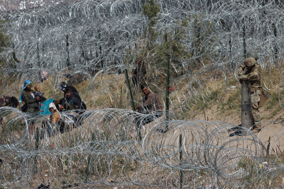 Migrantes llegan a una orilla del Río Bravo sembrada con alambre de púas, en Cudad Juárez, Chihuahua (México).