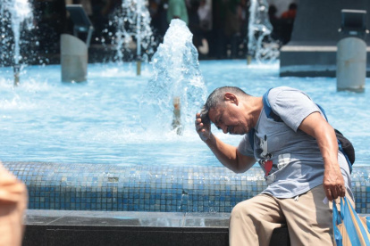 Un ciudadano se moja en una pileta en el centro de Guayaquil.