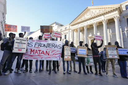 Integrantes de entidades sociales impulsoras de la iniciativa legislativa popular se manifiestan durante el debate en el pleno del Congreso de los Diputados, en Madrid.
