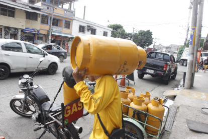 Guayaquil. Una persona que trabaja llevando tanques de gas camina al domicilio de uno de sus clientes.