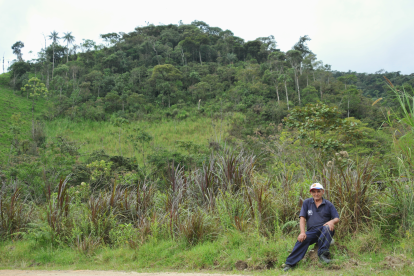 José Jiménez, de 81 años, posa delante del bosque que desde hace quince años protege, en San Andrés, Zamora Chinchipe.