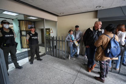 Ciudadanos venezolanos esperan información a las afueras del consulado de Venezuela, tras el anuncio del presidente Nicolás Maduro del cierre de la Embajada y consulados, en Quito (Ecuador).