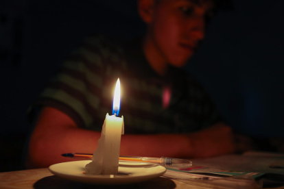Un estudiante lee un texto a la luz de una vela este miércoles en Quito (Ecuador).