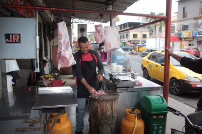 José Vera corta la carne con hacha, no puede usar la cortadora eléctrica por el apagón.