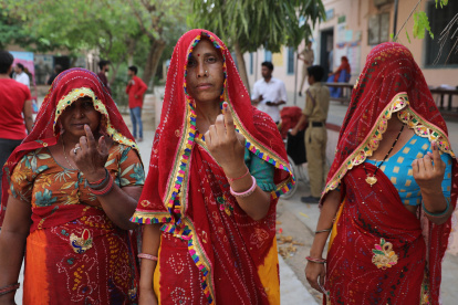 Mujeres indias muestran sus dedos con tinta tras votar en la primera fase de las elecciones generales, en la aldea de Shahpura, en las afueras de Jaipur, Rajasthan.
