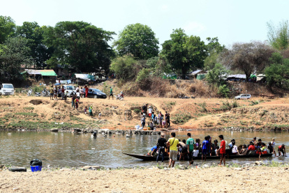BIrmanos cruzan el río Moei en la frontera entre Birmania y Tailandia para huir de los enfrentamientos entre las fuerzas pro y anti junta militar.