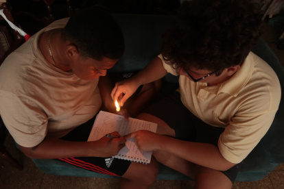 Ocio. Algunas familias aprovechan para disfrutar de juego de mesas a la luz de las velas.