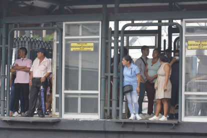 Las personas esperan los buses en las paradas