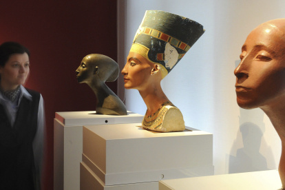 Una mujer que observa el busto de Nefertiti