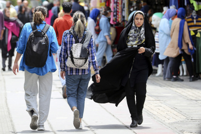 Varias mujeres con y sin velo caminando por una calle de Teherán (Irán).