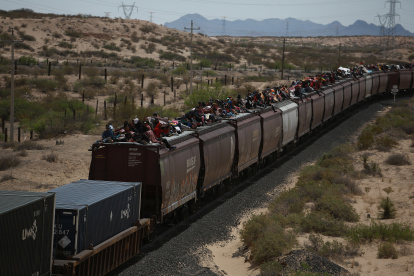 Migrantes viajan en el techo de un tren conocido como "La bestia", el 25 de abril de 2024 en Ciudad Juárez (México).